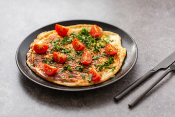 Omelet with tomatoes and herbs. Delicious breakfast