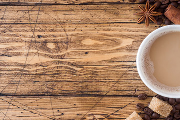 Cup of coffee, brown sugar and cinnamon with anise on a wooden background. Copy space