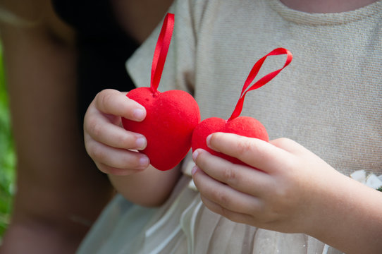 Red hearts in children's hands. The girl is holding red hearts. Concept family, happiness, love, valentine's day