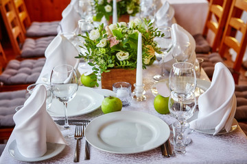 Simple and elegant table for a festive or wedding event, decorated in green and white