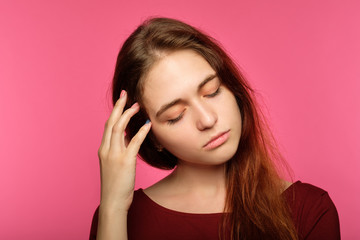 tired sad young woman. portrait of a sleepy drowsy and exhausted pretty girl on pink background.