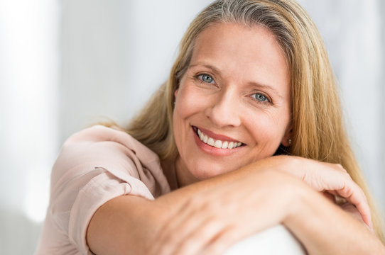 Fototapeta Smiling mature woman on couch