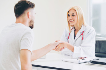 Doctor shake hand with patient in the hospital.