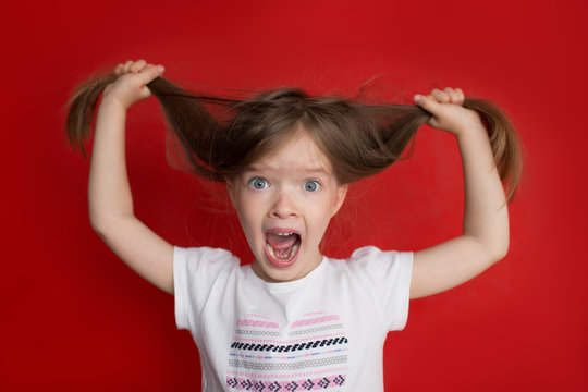 portrait of crazy little girl on red background