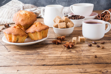 Breakfast coffee with milk, pastries, brown sugar and cinnamon with anise on wooden background. Copy space