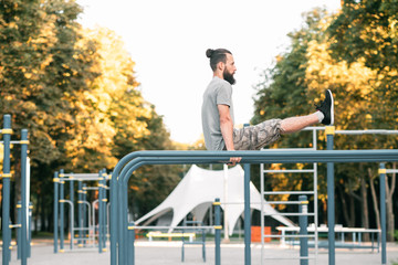 outdoor exercises and street workout. man training abdominal muscles.
