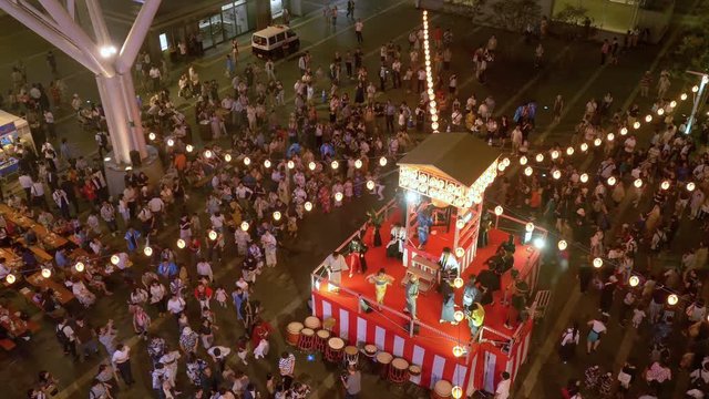Japanese summer festival “Bon-odori” in aerial shot. People dancing in circle