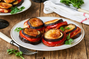 Baked eggplants and tomatoes with cheese on a plate