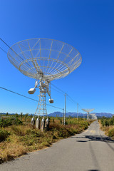 Array of satellite dishes or radio antennas against sky. Space o
