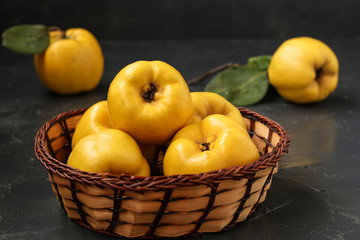 Ripe yellow quince fruit on dark background in a wicker basket, healthy lifestyle, nutrition Copy space