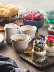 Cozy Breakfast concept on dark wooden textured background. Coffee and yogurt with home made granola