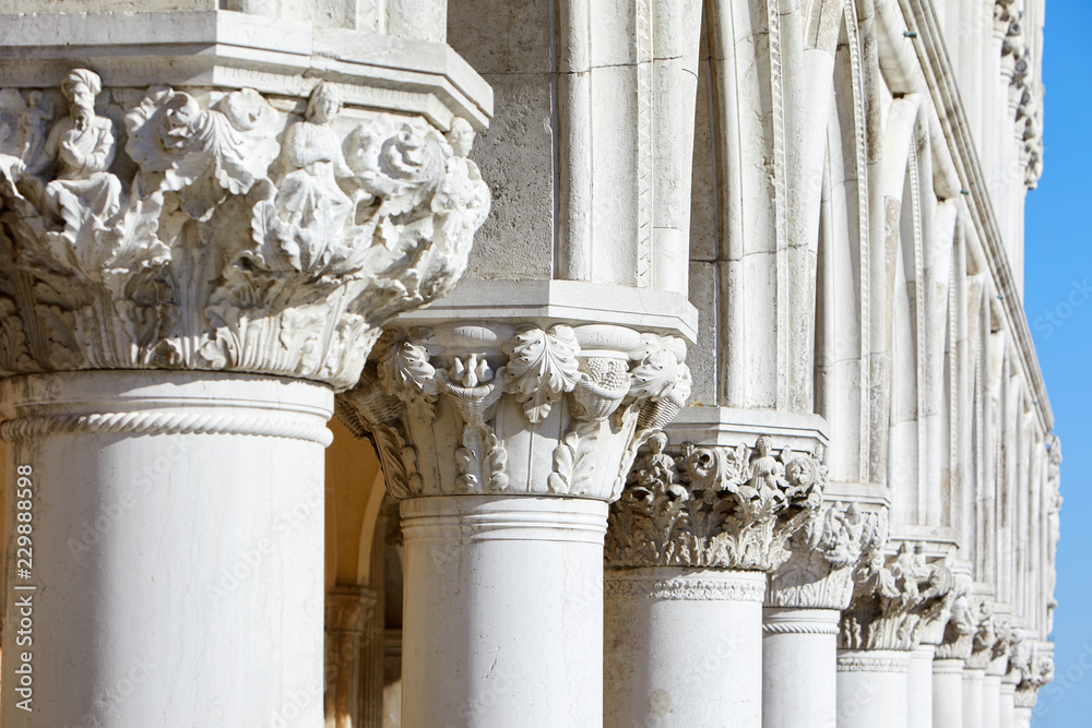 Wall mural venice, white capital sculptures of doge palace colonnade in a sunny day