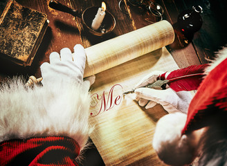 Santa Claus writing an Xmas greeting on a scroll