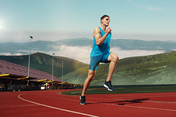 man running in the track. Fit male runner jogging during training at stadium tracks. The athlete, fitness, workout, sport, exercise, athletic, lifestyle concept
