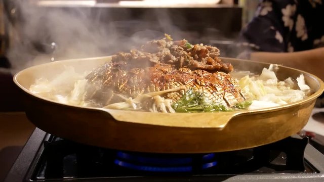 Motion of hot pot boiling and people eating food inside Chinese restaurant with 4k resolution