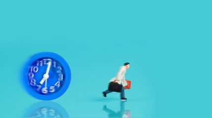 miniature people: businessman running and try to race against time and beat the clock to be a winner (Financial and Business competition concept).