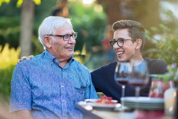 During a family picnic.Grandson laughing with grandfather