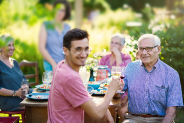 Summertime, cheerful family gathered for picnic in the garden