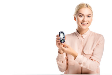 smiling woman putting strip into glucometer isolated on white, diabetes concept