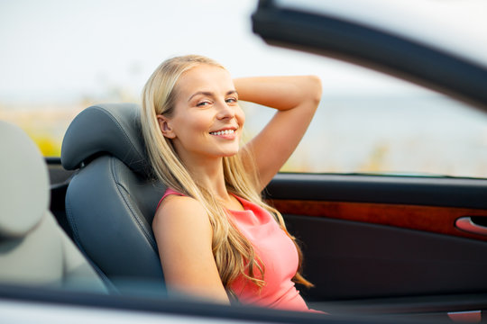 travel, road trip and people concept - happy young woman driving convertible car