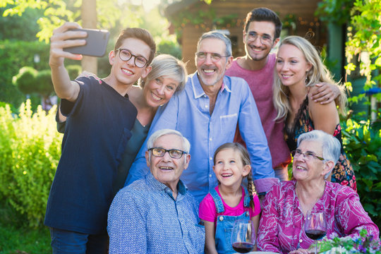 during a bbq a teenager does a selfie with the whole family