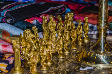 wooden chessboard with figures in the form of ancient warriors of metal