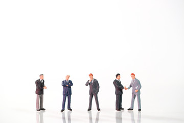 Miniature people: a group of businessman standing on white background (this image for financial and business competition concept).