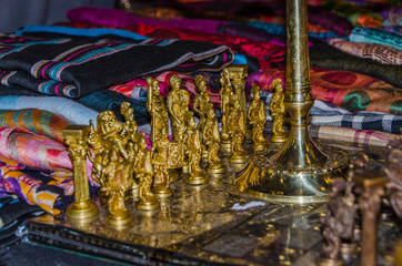 wooden chessboard with figures in the form of ancient warriors of metal