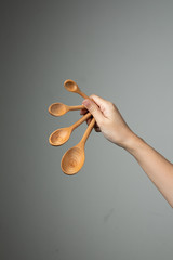 measure spoon table spoon tea spoon in hand grey background