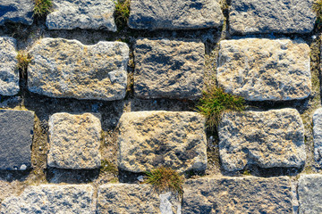 road lined with rough rough gray stone as background or texture.