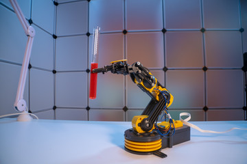 Test tube in robot arm. robot manipulates chemical tubes in the laboratory - Powered by Adobe