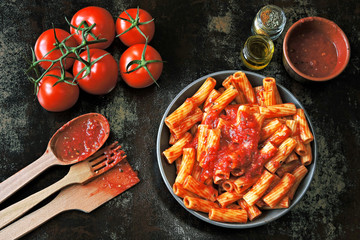 Appetizing Italian pasta with tomato sauce and spices. Pasta with tomato sauce in a bowl. Vegan lunch.