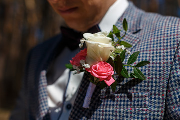 Elements of the groom's clothes on the wedding day. Blue butterfly, tuxedo and boutonniere with white roses