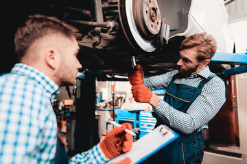 Young Mechanics Repairs Automotive Hub In Garage.