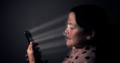 Young child using a smart phone with facial recognition technology with 3D face mapping