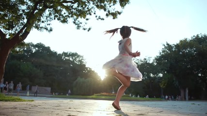 Joyful cute little lady in white romantic dress with flowers spinning in green park. Happy Caucasian kid. Naughty mood. Evening in summer. Outdoors. - Powered by Adobe