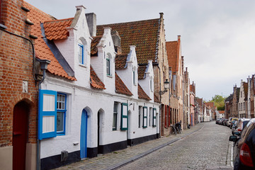 Traditional medieval architecture, narrow paved street with brick houses with red tiled roofs