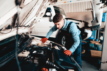 Young Auto Mechanic Is Looking Under The Hood.