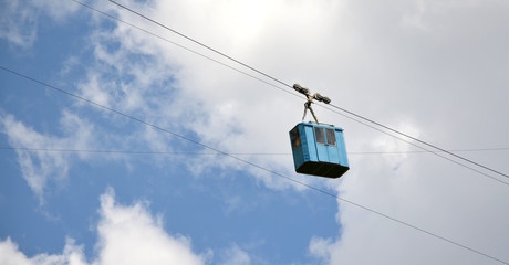 Alte Seilbahn in den Bergen, freigestellt vor blaugrauen Himmel