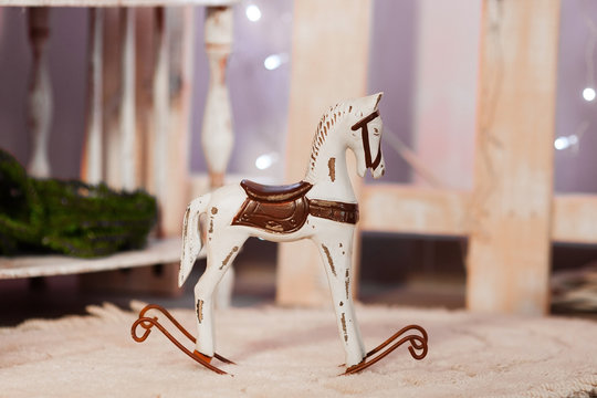The wooden toy horse  in front of bokeh background. Christmas background