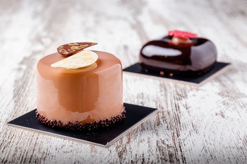 Chocolate cake with mini cookies over on rustic background.