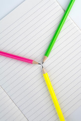Colored pencils are on the notebook.close-up