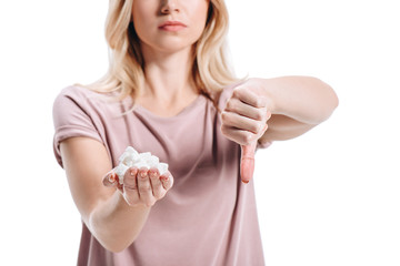 cropped image of blonde woman in casual shirt holding unhealthy white sugar and showing thumb down isolated on white