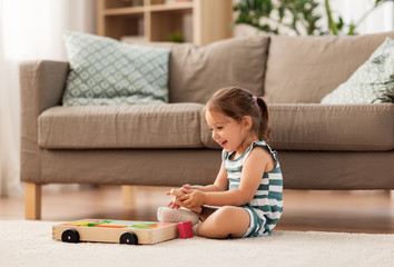 childhood and people concept - happy three years old baby girl playing with toy blocks at home