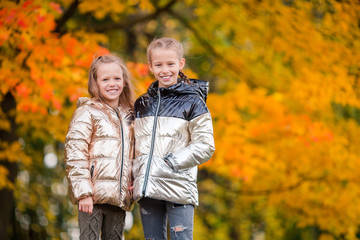 Fototapeta premium Little adorable girls at warm sunny autumn day outdoors