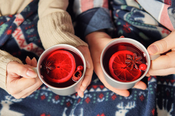Top view of the couple holding mugs with mulled wine