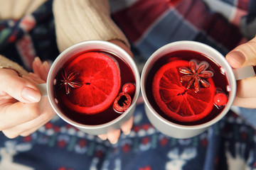 Top view of the couple holding mugs with mulled wine