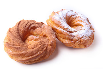 Chocolate and powdered sugar cream puff rings, choux pastry. Isolated on white background.