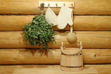 Accessories for a sauna on the background of the log wall in the interior of the Russian bath.