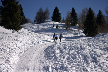 Fototapeta na wymiar Walking on the snowy path towards the top of the mountain